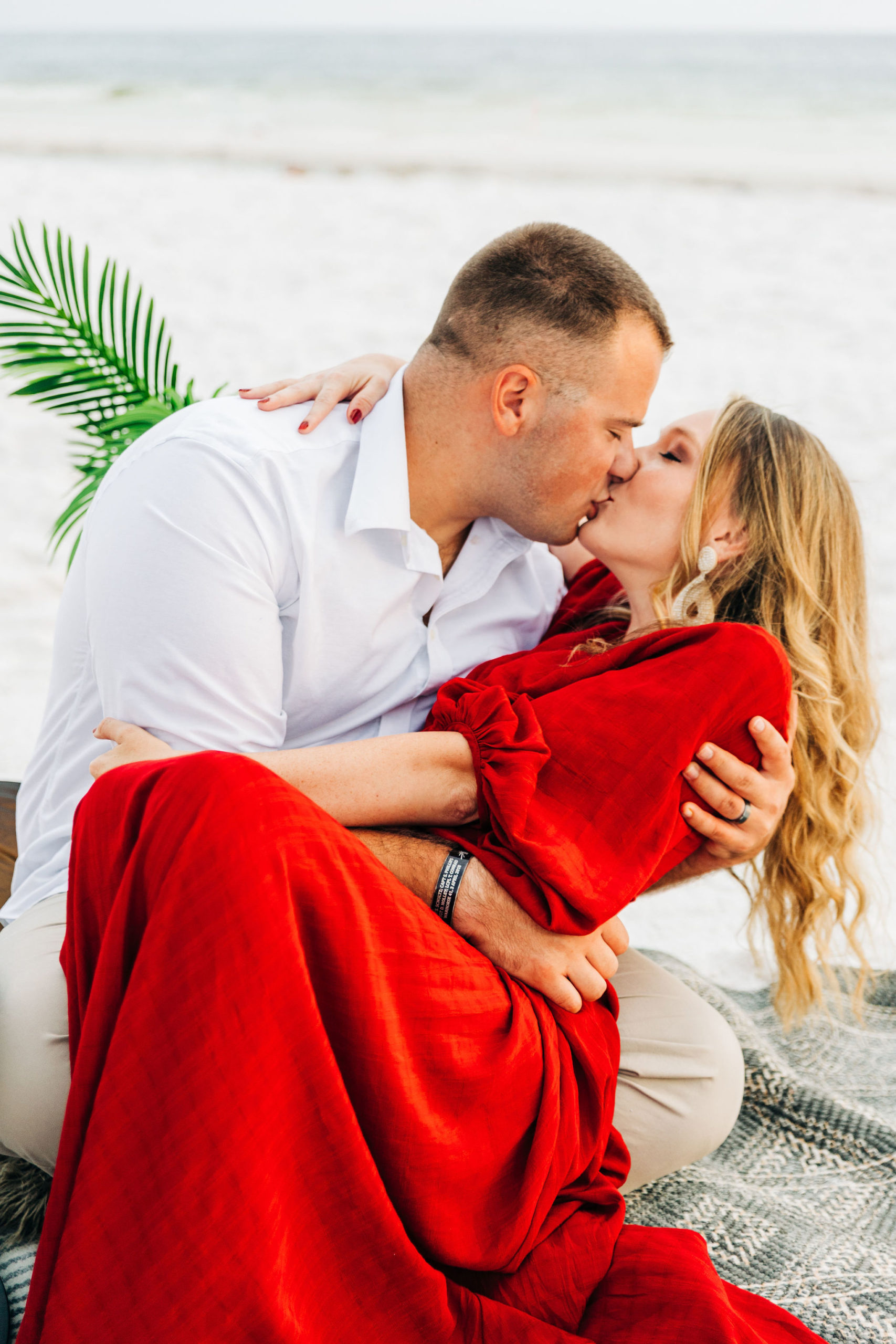 Kallie and Noah kiss at the sunset beach picnic