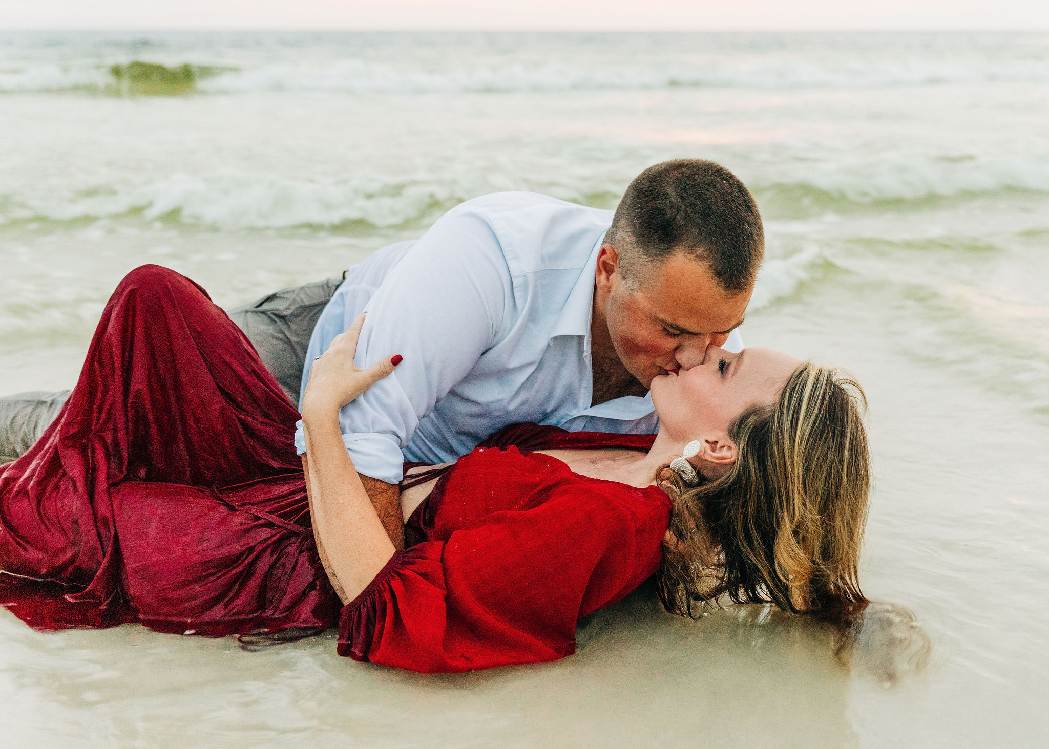 Kallie and Noah hold back laughter as he rolls her over in the water and kisses her