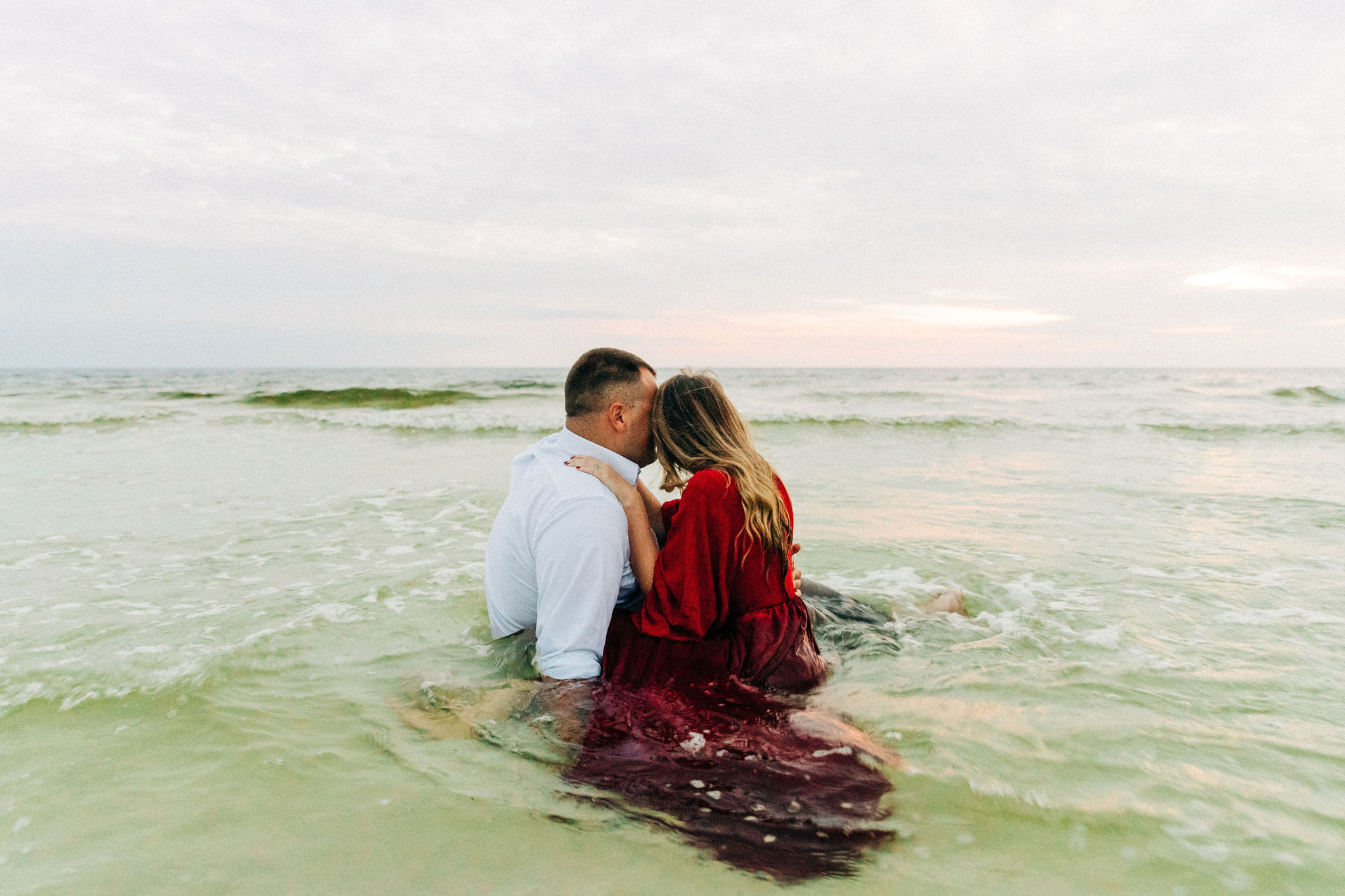 Kallie and Noah hold one another as the tide comes in and water swirls around them